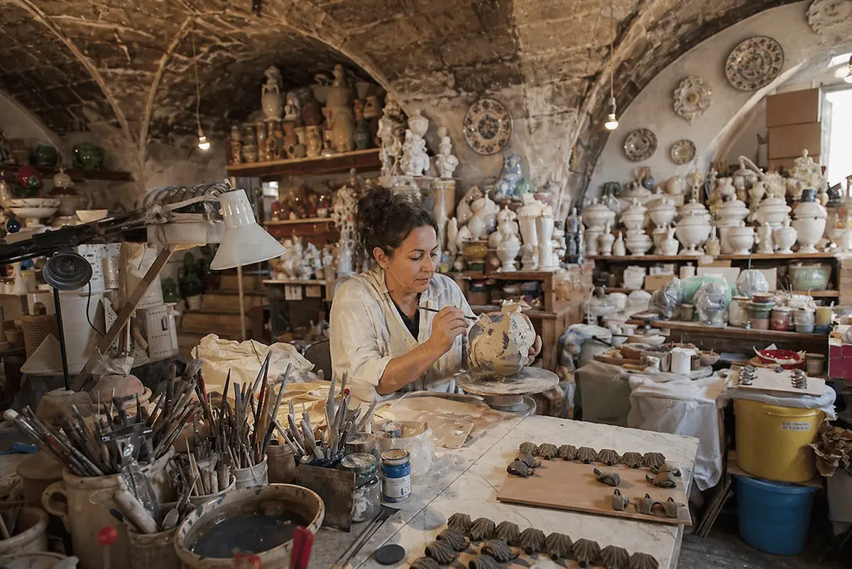 Artigiano della ceramica a Grottaglie al lavoro in laboratorio artigianale, attività locale in Puglia che può crescere con siti web, SEO e marketing digitale a Grottaglie